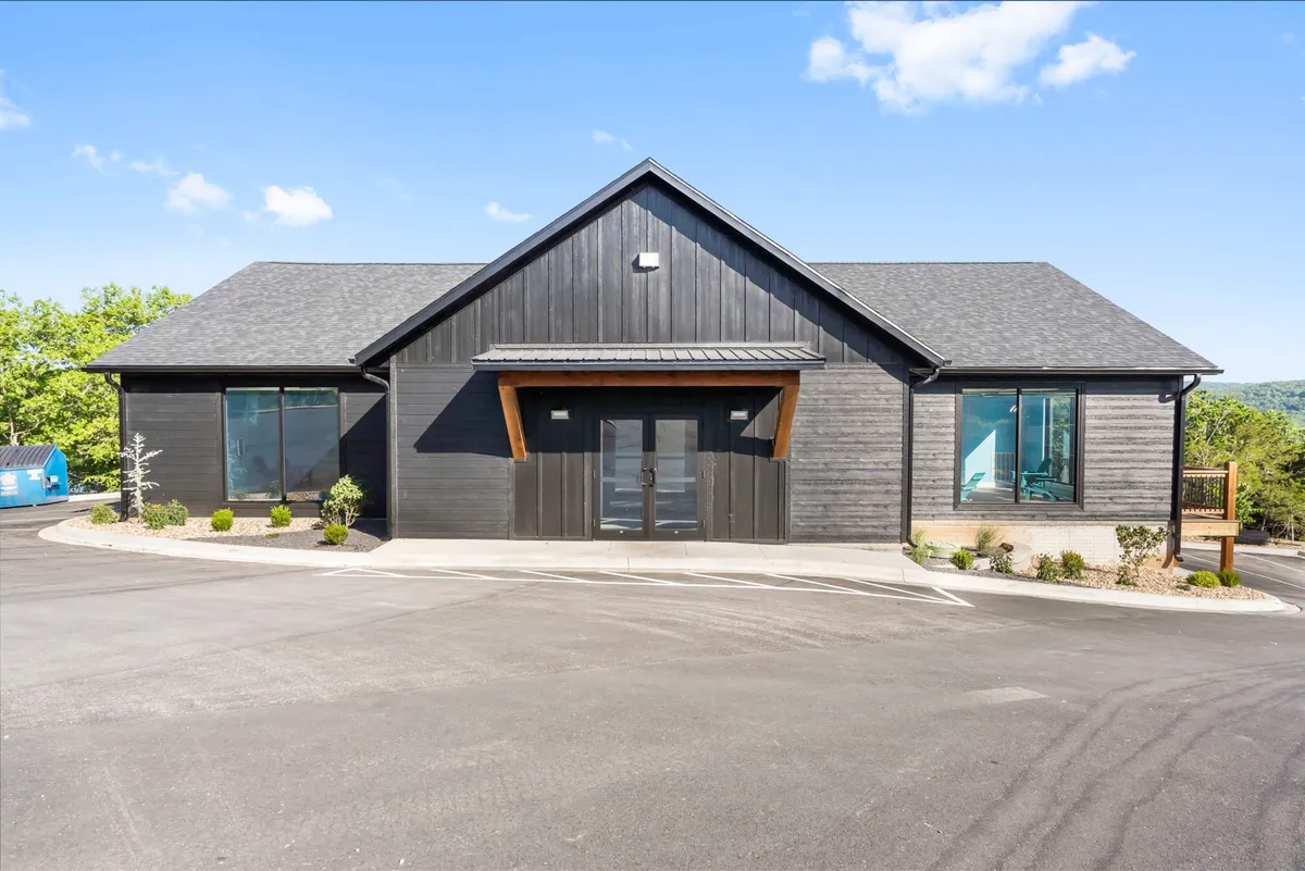 A modern exterior view of the property featuring clean architectural lines, wooden accents, and large windows that let in natural light. The inviting front area suggests a welcoming entrance, ideal for guests returning from local events.