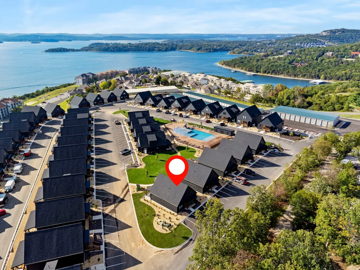 This vibrant exterior image showcases the community’s sparkling outdoor swimming pool, with children playing, families gathering, and houses neatly arranged along landscaped pathways. The scene radiates activity and togetherness, perfectly capturing the spirit of fun and social connection.